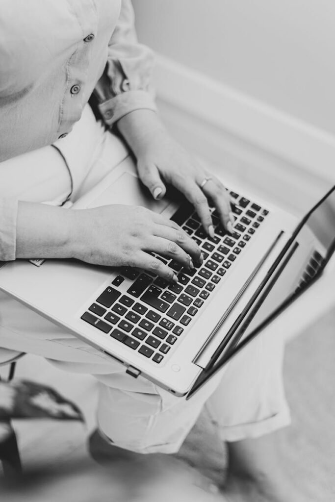Close-up of a woman typing on a laptop, emphasizing work and focus.